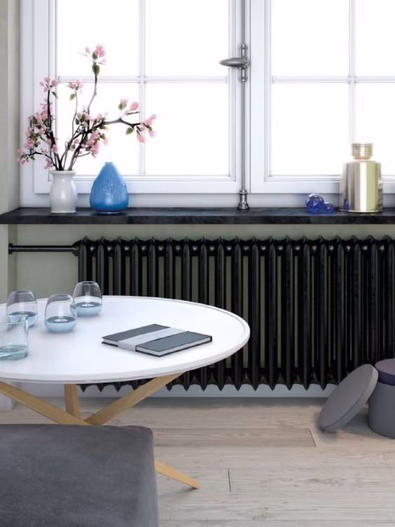 Kaloryfer pomalowany odcieniem Black z kolekcji Beckers Designer Universal. Ściana w salonie w kolorze Healing Grey z palety Beckers Designer Colour