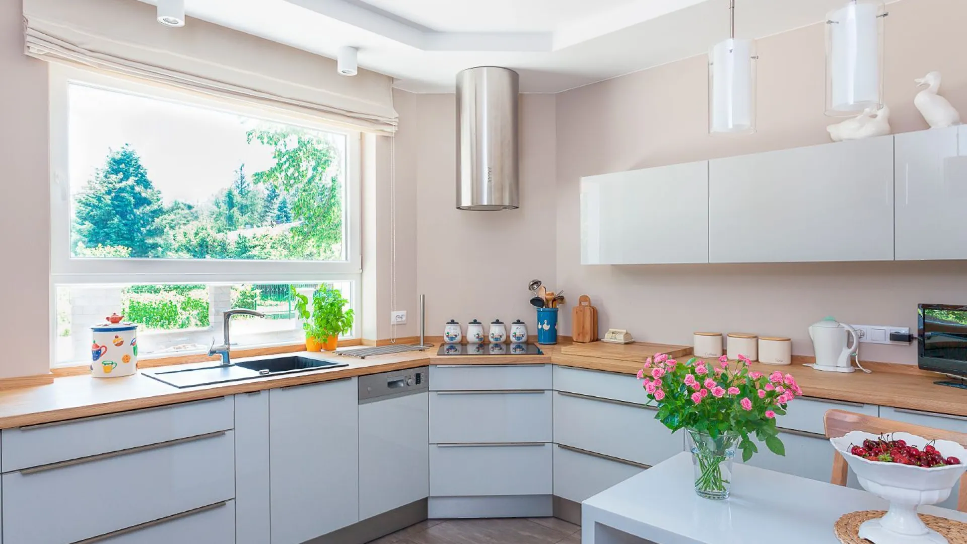 Biała i funkcjonalna kuchnia z drewnianym blatem